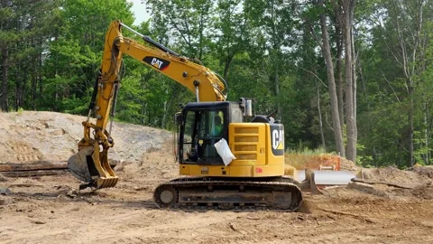 CASS CO, MN - 6 AUG 2021: Yellow CAT Excavator on construction site in forest. Stock Footage 159731959