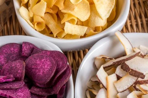 Cassava chips, coconut chips and purple sweet potato chips served in bowl Stock Photos