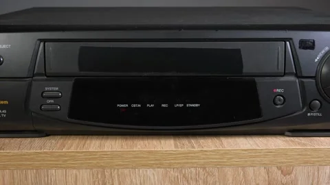 A cassette is inserted into a VCR, an old VCR, technology from the last century Stock Footage 265014842