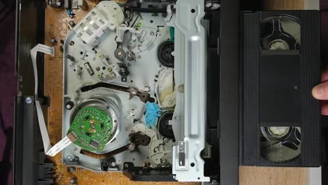 A cassette is inserted into a VCR, an old VCR, technology from the last century Stock Footage 265145645
