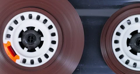 Cassette reels spin during analog playback with orange accents Stock Footage 344985494