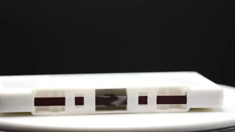 Cassette tape falling in slow motion Isolated on black Video stock 169982014