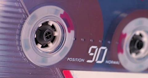Cassette tape reels spin during analog playback in closeup Stock Footage 344996217