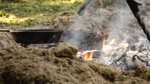 Cast-iron frying pan stands on metal stand at stake. Stock Footage 268068520