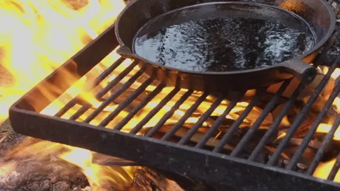 Cast iron pan with removable handle is seasoned with oil on open fire Vidéo 270660786