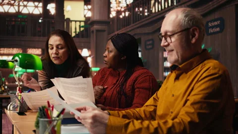 Cast members practicing script reading for a classic drama play in a library Stock Footage 313310686