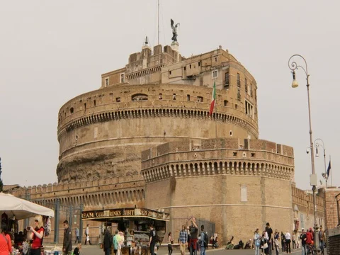 Castel Sant’Angelo in front of the Tiber River, with stalls and tourists who str Stock Footage 73988582
