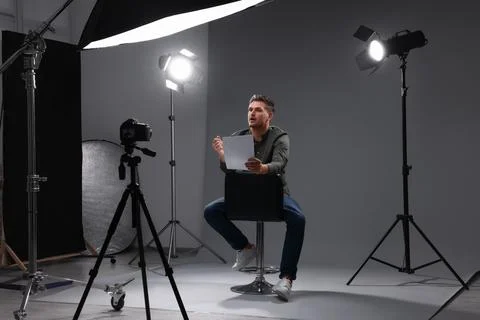 Casting call. Man with script sitting on chair and performing in front of c.. Stock Photos