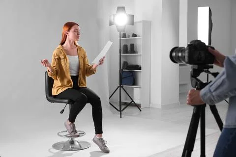 Casting call. Woman with script performing while camera operator filming he.. 写真素材