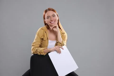 Casting call. Young woman with script on chair against grey background, spa.. Stock Photos