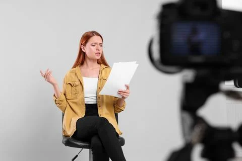 Casting call. Young woman with script performing in front of camera against.. Stock Photos