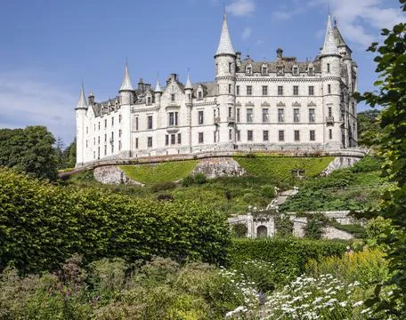 A castle with a clock tower in front of a building Stock Photos