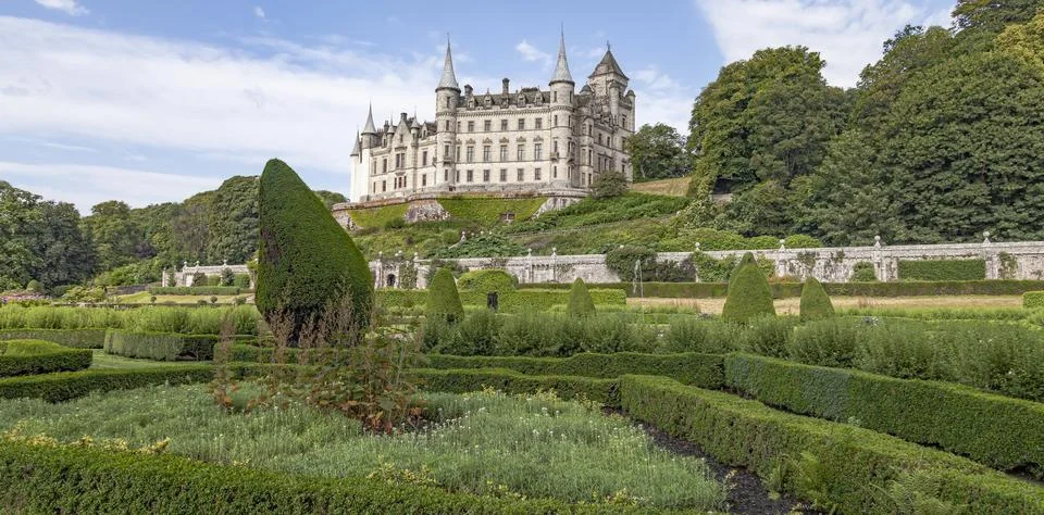 A castle with a clock tower in front of a building Stock Photos