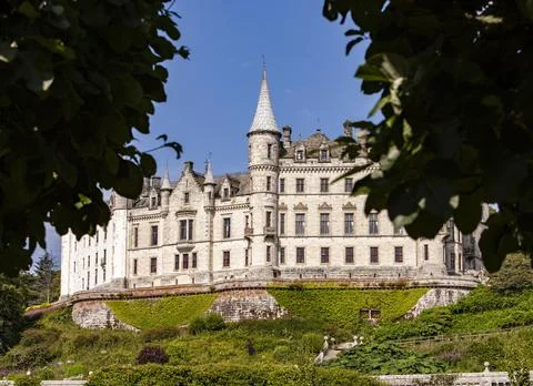 A castle with a clock tower in front of a building Stock Photos