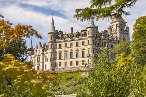 A castle with a clock tower in front of a building Stock Photos