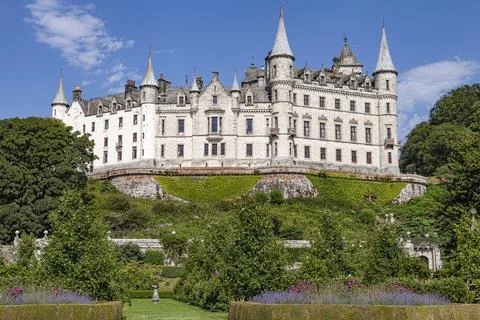 A castle with a clock tower in front of a building Foto stock
