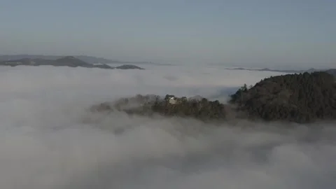 Castle floating above sea of clouds at sunrise, aerial drone view, Japan Video stock 331938985