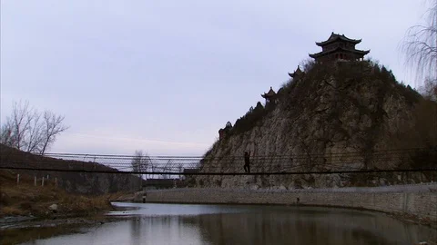 Castle on the hill, man walking on a bridge over the river Stock-Footage 88375708