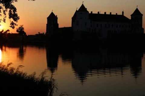 Castle reflected in the water at sunset Stock Photos