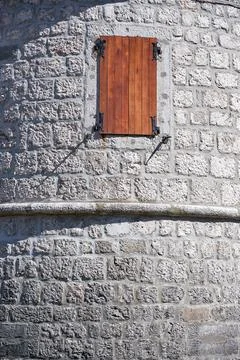 Castle round tower of bricks with lonely window and wooden shutter Stock Photos