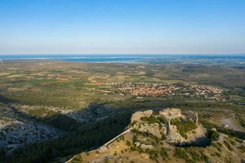 Castle ruins above patchwork fields and coastline Stock Photos