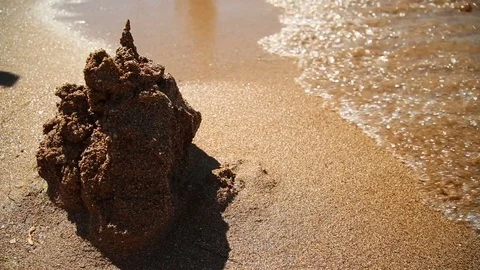 Castle on the sand is washed off by a sea wave Stock Footage