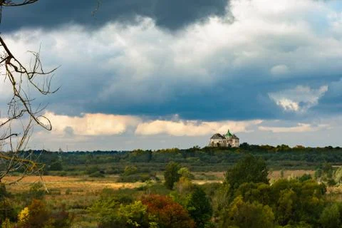 Castle on the sky with clouds and fields with yellow and red bushes. Stock Photos