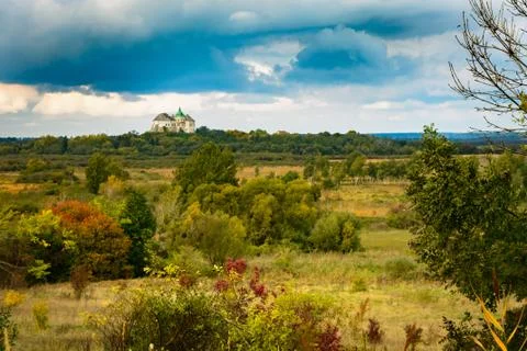 Castle on the sky with clouds and fields with yellow and red bushes. Foto stock