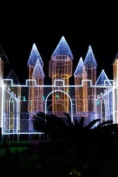 The castle structure illuminated with multi-colored lights from garlands at.. Stock Photos