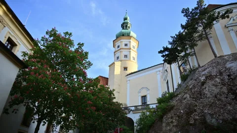 A castle tower with a green copper dome beside a blossoming chestnut tree, Stock Footage 342239686