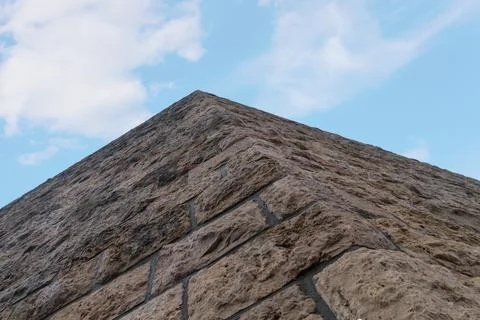 Castle wall of brown stone rises against the blue sky Stock Photos