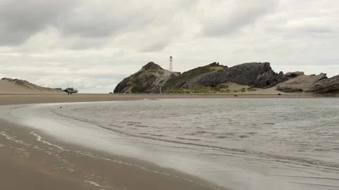 Castlepoint lighthouse from the sandy beach. Castlepoint, New Zealand. Stock Footage 136731680
