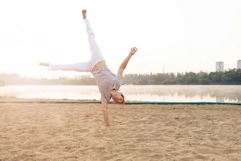Casual athletic man on the beach while workout Stock Photos
