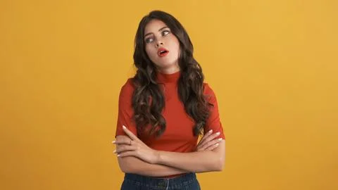 Casual bored girl in red top with hands crossed tiredly posing on camera over Stock Photos