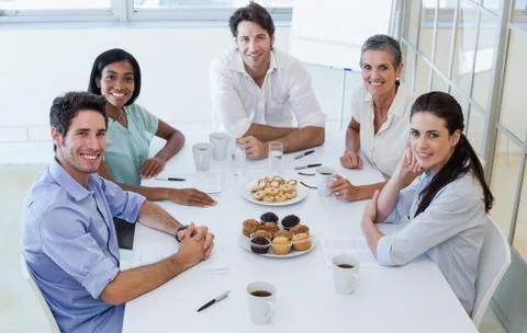 Casual business team having a meeting smiling at camera Stock Photos