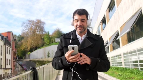 Casual businessman dancing while listening to music in the city Stock Footage 295346497