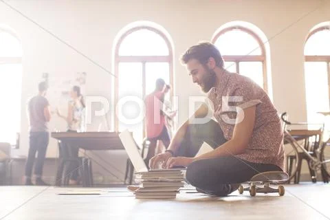 Casual businessman working at laptop from skateboard Stock Photos