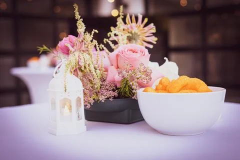 Casual chic table setting with snack food with pink flowers and tea lamp Stock Photos