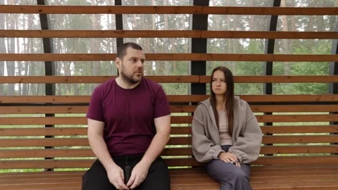 Casual Conversation Between Man and Woman Sitting on Wooden Bench in Forest.. Stock Footage 310828672
