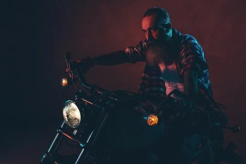 Casual cool long beard man on motorcycle at night. Foto stock
