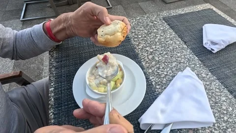 A Casual Dining Experience Featuring a Hand Holding a Bun with a Dessert Bowl of 库存影片 331079154