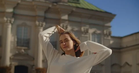 Casual dressed dancer poses in slow motion in old town. Lifestyle city Stock Footage 166089100