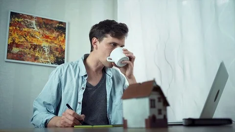 Casual dressed guy using graphic tablet creating housing project on laptop Stock Footage 79902590