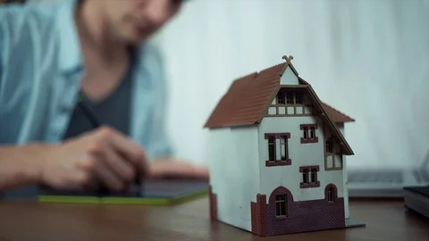 Casual dressed guy using graphic tablet creating housing project on laptop Stock Footage 79902903