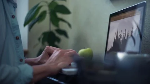 Casual dressed young man using laptop making notes in notepad at home Video stock 82932416