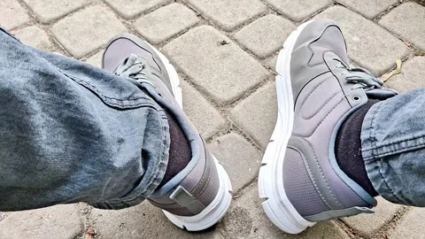 Casual First Person View of Gray Sneakers While Sitting Outdoors Stock Footage 337923739