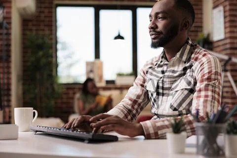 Casual freelancer typing on computer keyboard while looking at screen working 스톡 사진