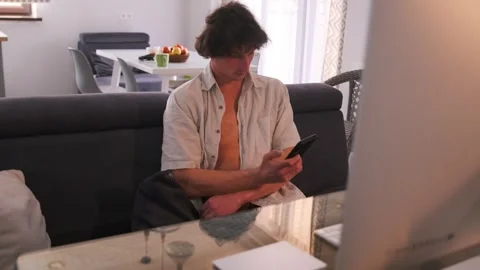 Casual man balances work and leisure, Relaxed man in modern apartment using Stock Footage 331281050