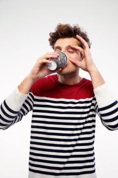 Casual man drinking coffe with closed eyes on gray background 스톡 사진