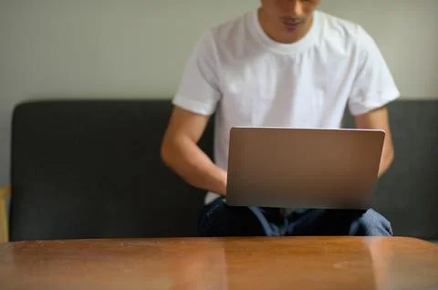 Casual Man Using Laptop While Sitting on Couch at Home Stock Photos